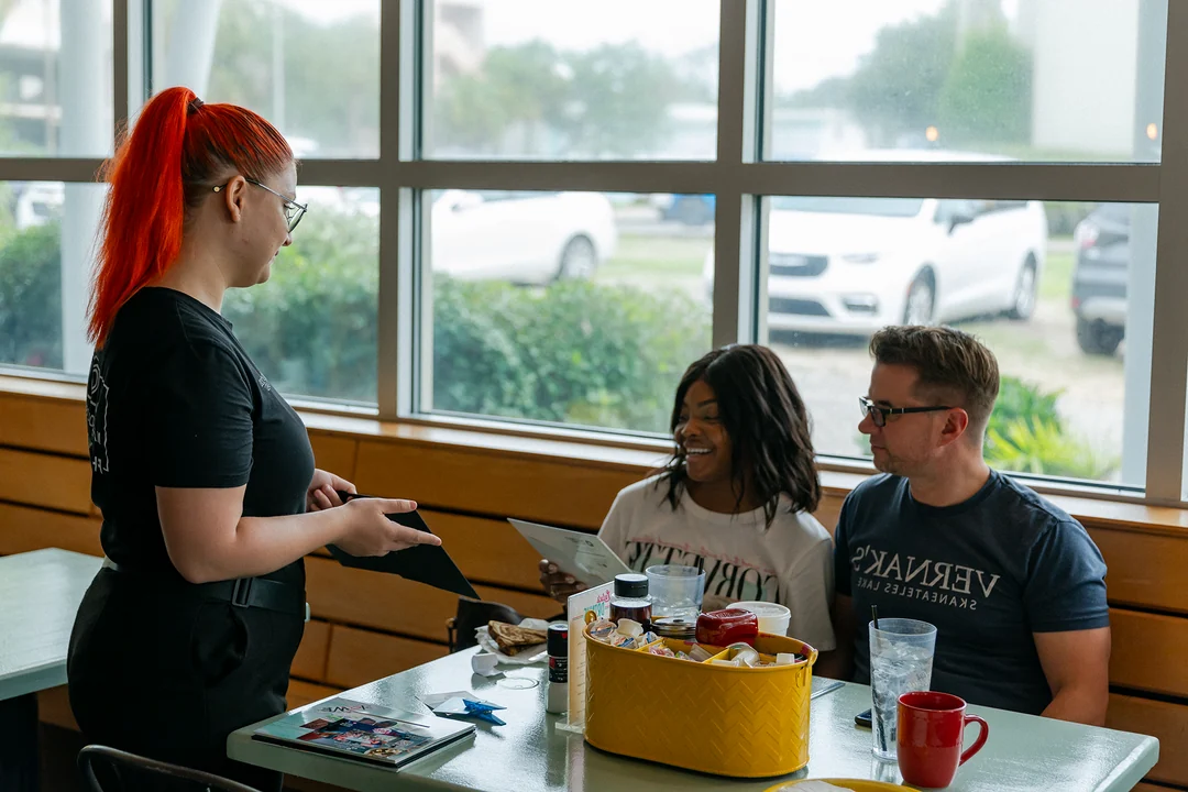 Photographer speaking with smiling guests at their restaurant table